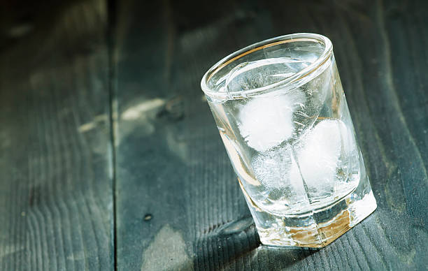 istock Clold fresh water with ice in glass on dark background 475438156