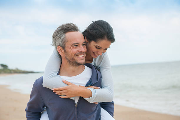 istock beautiful couple is posing holding eachother at the beach 475438222