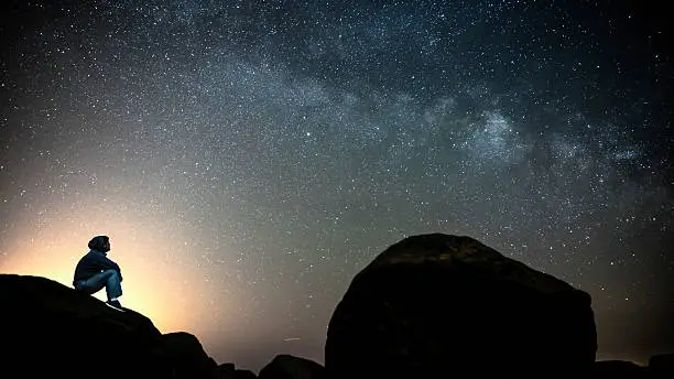 Photo of Man looking at the Milky Way galaxy