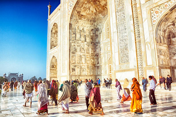 Tourists at the Taj Mahal Tourists visit the Taj Mahal in Agra, India. india tourism stock pictures, royalty-free photos & images
