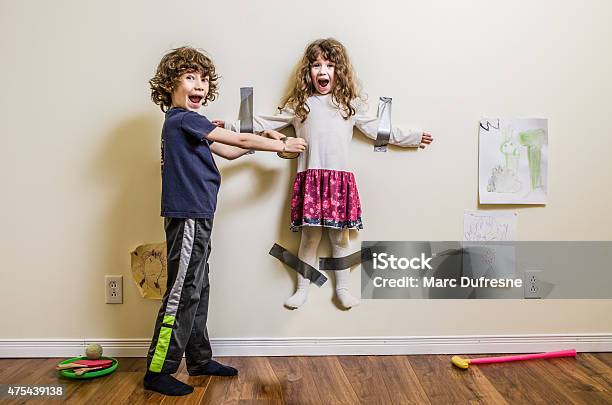 Brother Hung Su Hermana En La Pared Foto de stock y más banco de imágenes de Niño - Niño, Humor, Hermanos