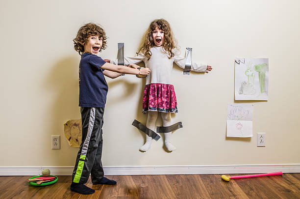 fratello, sorella appesi sulla parete - bullying child teasing little boys foto e immagini stock