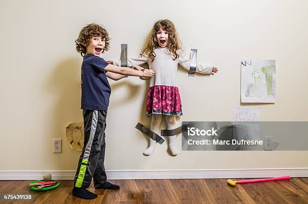 Brother Hung Her Sister On The Wall Stock Photo - Download Image Now - Child, Humor, Evil