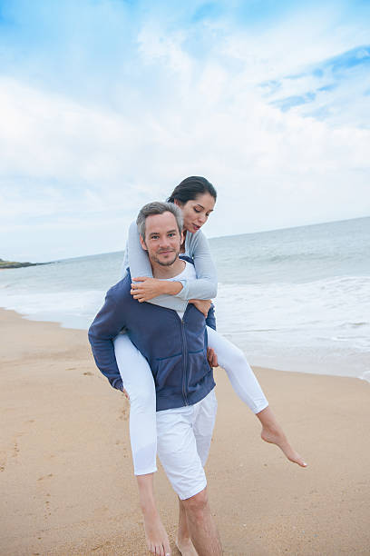 istock man is carrying his girlfriend on the beach 475439770
