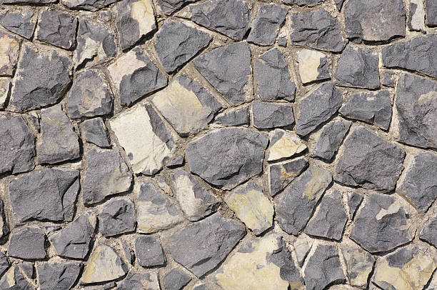 istock Wall of black volcanic rocks closeup 475439790