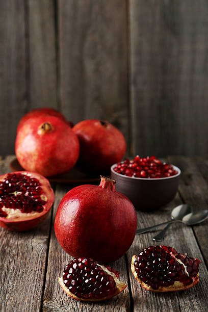 istock Delicious pomegranate fruit on grey wooden background 475439892
