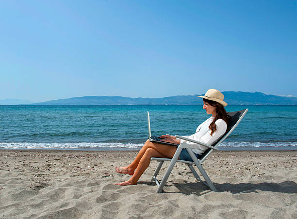 istock Woman working on the beach with laptop 475439932