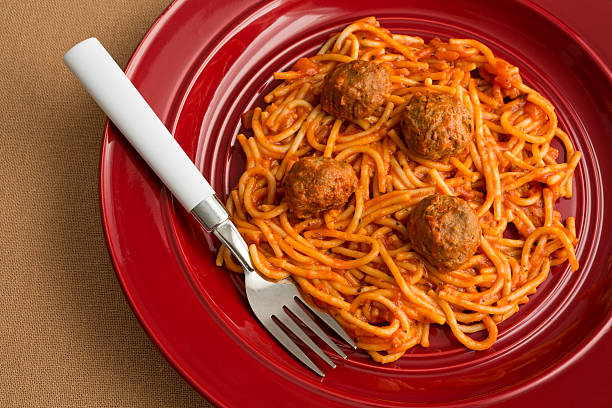 istock Spaghetti and meatballs on a red dish with fork. 475440588
