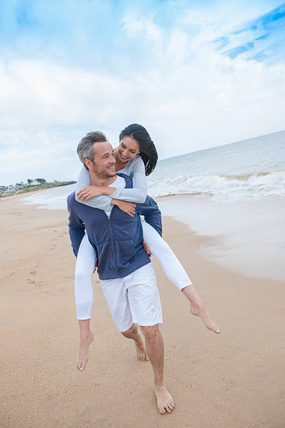 istock man is carrying his girlfriend on the beach 475441204