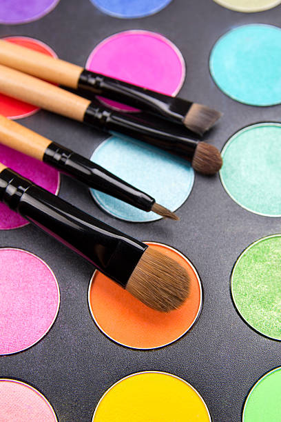 istock Make-up brushes and colorful eyeshadow palette over black 475441213