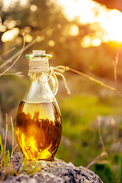 Little bottle with olive oil with lens flare and sun light stock photo