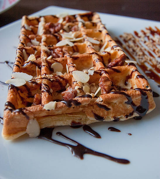 istock Sweet waffle with almonds and chocolate syrup 475442056