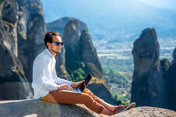 hombre con ordenador portátil en la montañas - on top of business cliff businessman fotografías e imágenes de stock