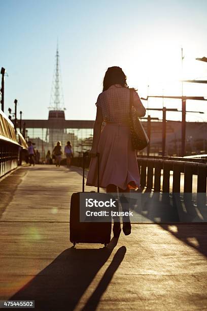 Young Woman Walking Sidewalk And Carrying Suitcase Stock Photo - Download Image Now - 2015, Activity, Adult