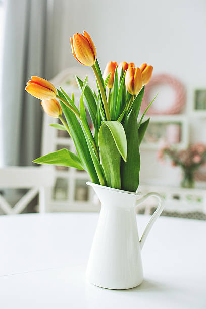 istock Beautiful orange flowers in vase on rustic kitchen table 475445674