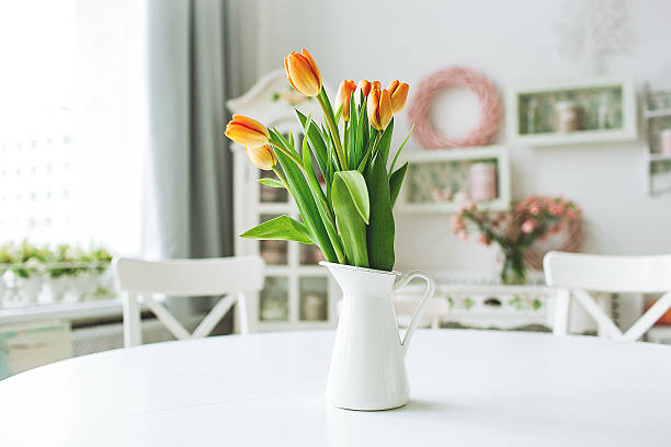 istock Beautiful orange flowers in vase on rustic kitchen table 475445700