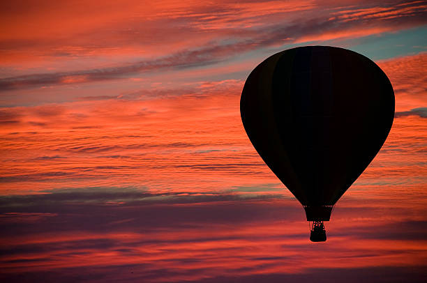 istock Hot-air ballooning among pink and orange clouds 475446338