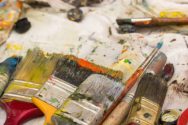 istock Paintbrushes on abstract painted canvas. Oil paints, colorful background. 475448334