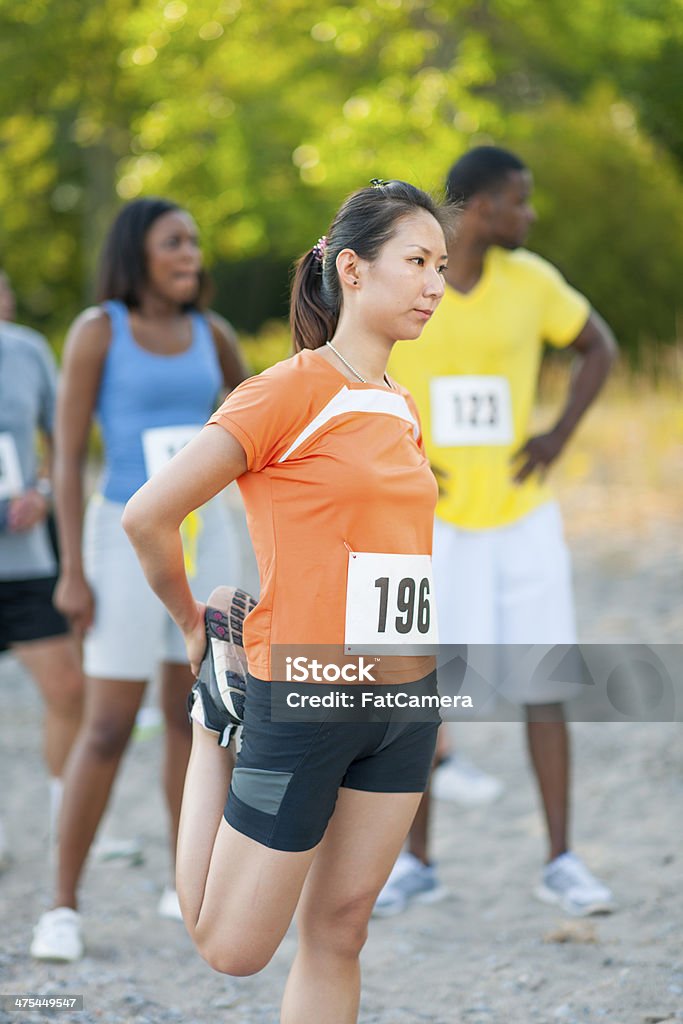 Stretching A runner stretching before a race. 5000 Meter Stock Photo