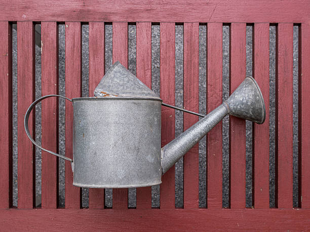 istock Watering can on wooden bench with copy space 475450168