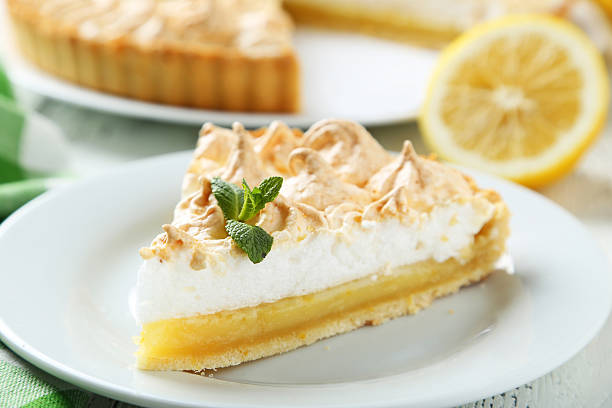 istock Lemon meringue pie on plate on white wooden background 475450312