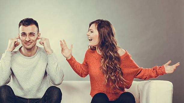 Angry fury woman screaming man closes his ears. couple having argument - conflict, bad relationships. Angry fury woman screaming man closing his ears. man closing ears photos stock pictures, royalty-free photos & images