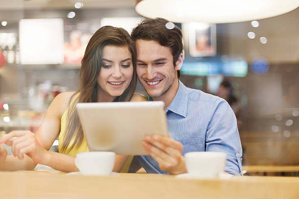 istock Couple have fun with digital tablet in cafe 475453163
