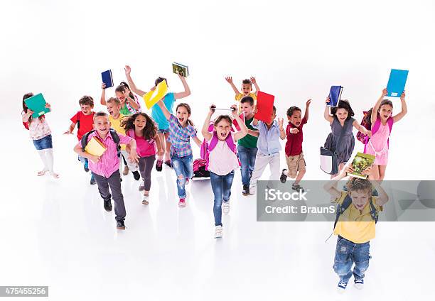 Crowd Of Cheerful Elementary Students Running With Books Stock Photo - Download Image Now