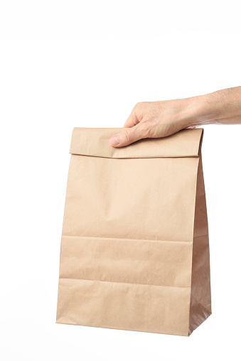 Holding a blank brown paper bag isolated on white background with clipping path.