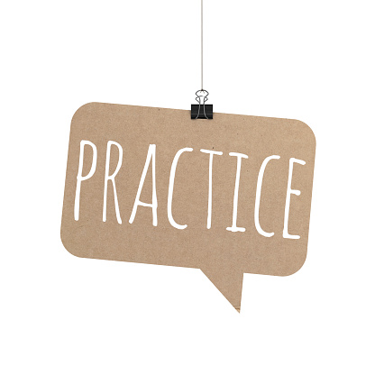 A  3D representation of a speech bubble hanging on a plain white background. The speech bubble is hanging from a binder paper clip that is attached to a piece of string. The bubble has a cardboard texture. The background is pure white. written on the speech bubble in white text is Practice