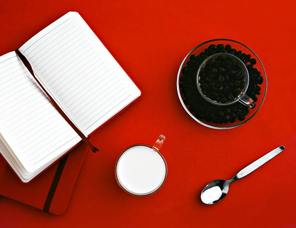 bloco de notas e grão de café sobre um fundo vermelho - coffee book instant coffee cappuccino - fotografias e filmes do acervo
