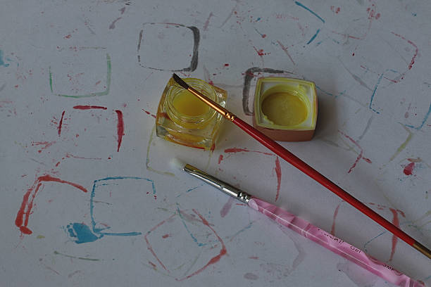 istock paint on a dirty canvas with brushes 475460374