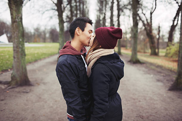 teenager paar küssen im freien im park - teenage couple stock-fotos und bilder