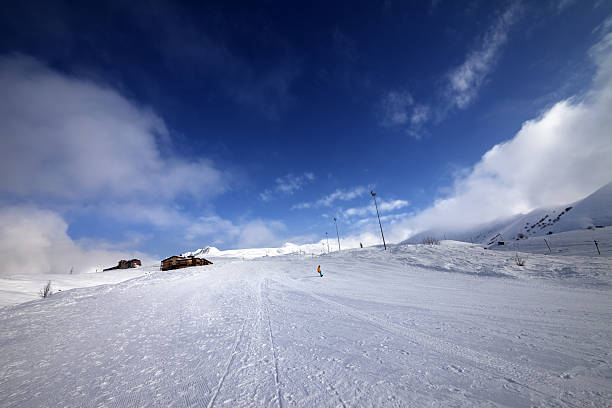 istock Snowboarder on piste slope in nice day 475461210