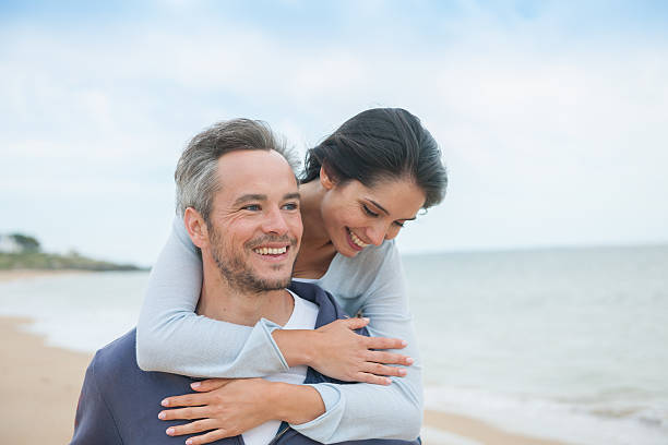 istock beautiful couple is posing holding eachother at the beach 475461672
