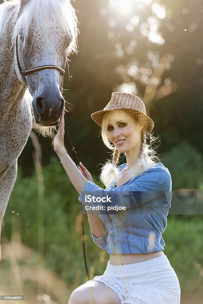 Donna e cavallo nel prato d'estate - Foto stock royalty-free di Abbigliamento casual