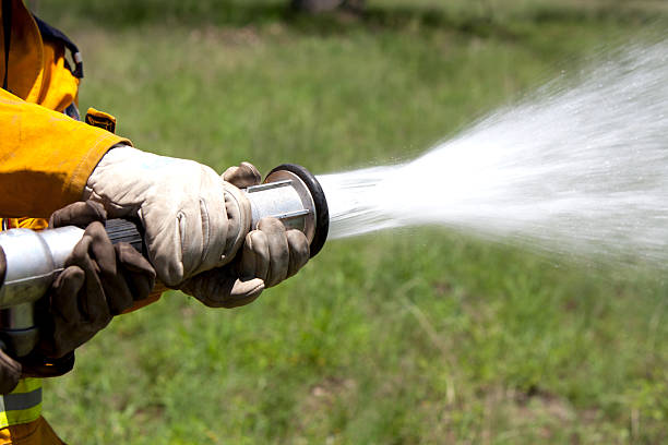 Fire fighter with hose Fire fighters holding hose while spraying water. fire hose stock pictures, royalty-free photos & images