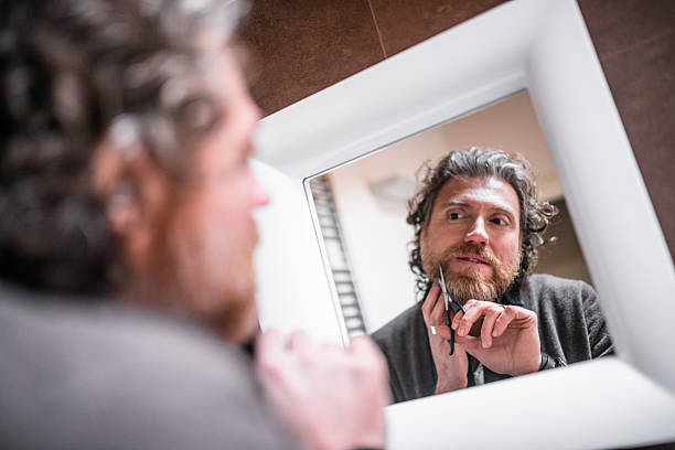 istock cutting the beard in front of mirror 475476632
