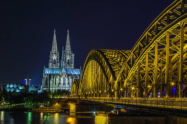 view of Cologne Cathedral with Hohenzollern Bridge in evening, Germany