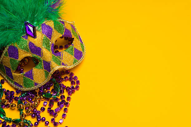 Colorful Mardi Gras or venetian mask on a yellow A festive, colorful mardi gras or carnivale mask on a yellow background.  Venetian mask. new orleans mardi gras stock pictures, royalty-free photos & images