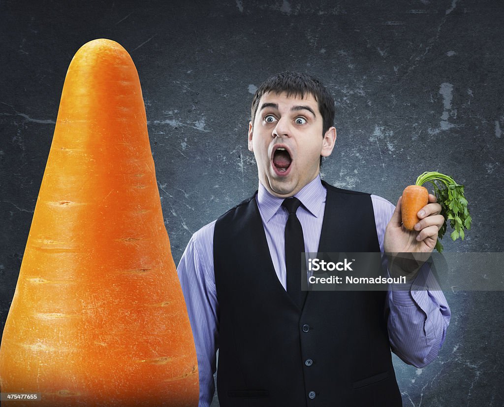 Carrot in hand and hude at a distance Small carrot in hand and hude at a distance Adult Stock Photo