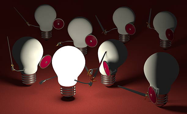 istock Glowing lightbulb fighting against many switched off ones on red 475480075