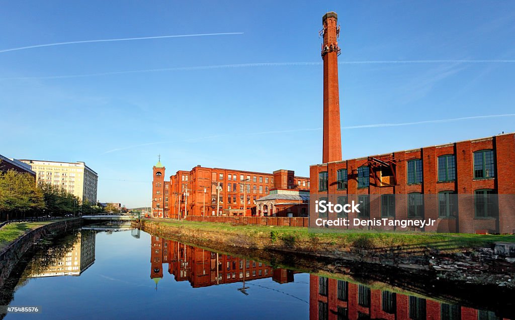 Lawrence, Massachusetts Lawrence mills reflecting on a canal. Lawrence is a city in Essex County, Massachusetts located twenty-five miles north of Boston. Lawrence was built in the 1840's as the nation's first planned industrial city 2015 Stock Photo