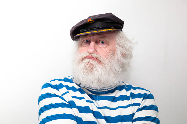 bearded senior sailor with cap and striped jersey  - on plain background