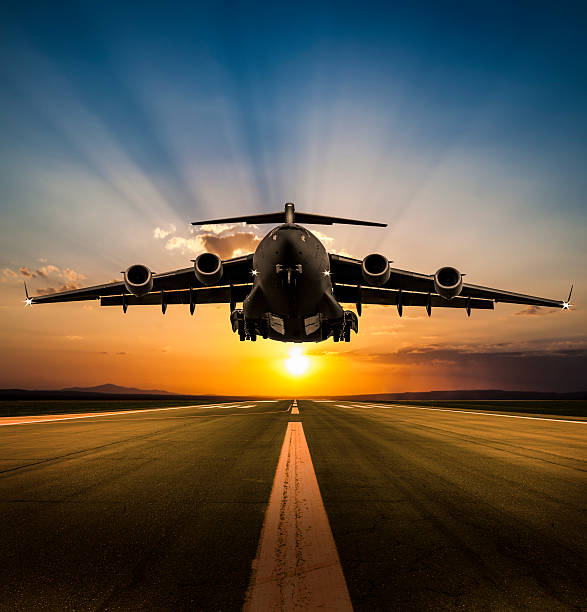 Cargo Airplane landing at sunset Cargo Airplane landing at sunset military airplane photos stock pictures, royalty-free photos & images