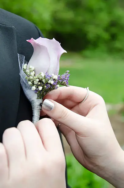 Pinning on a boutonniere on prom night.