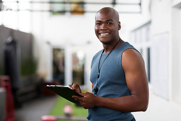 afroamerikanische männliche trainer mit zwischenablage - fitness trainer stock-fotos und bilder