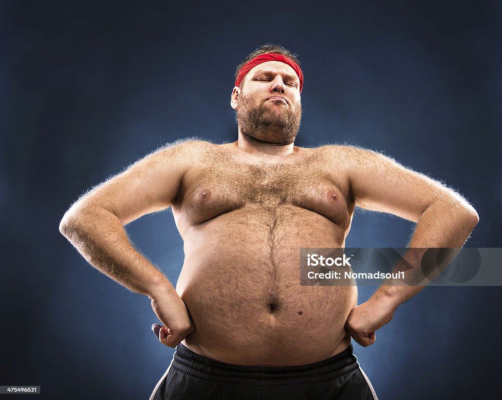 Fat man imitating muscular build Fat man imitating muscular build. Low angle view Men Stock Photo