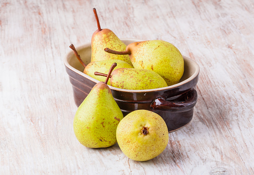 Pears in bowl on a wooden table. studio shot