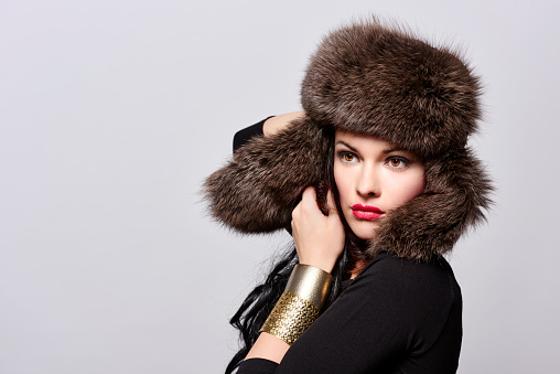 Beautiful caucasian young woman wearing a fur hat.